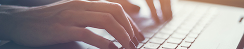 mujer con uñas rojas escribiendo en un teclado