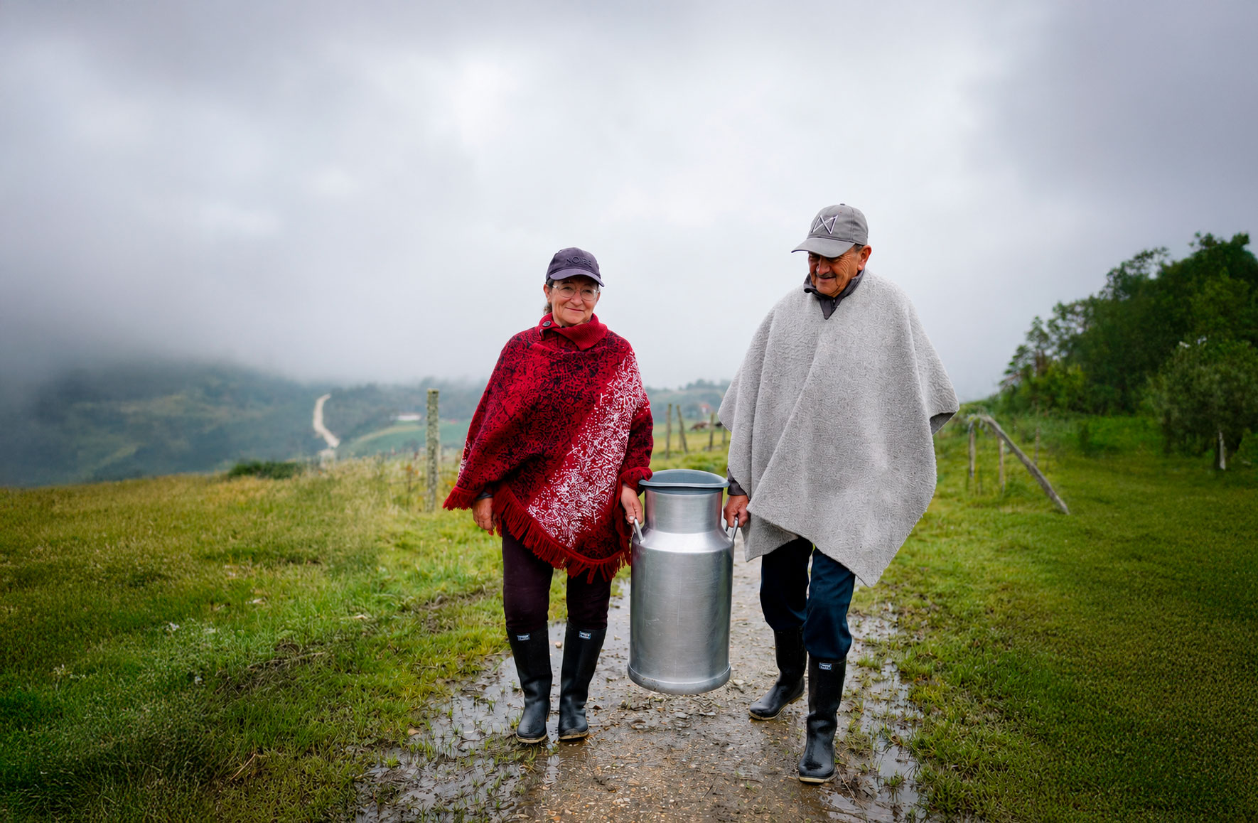 día de la leche 2026 2 campesinos hombre y mujer cargando una cantina de leche grande